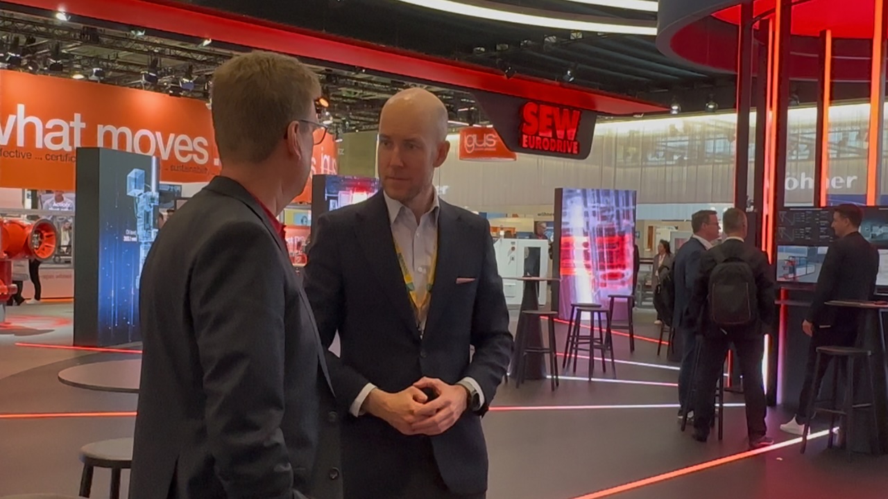 Bartosz hablando con un hombre en SEW Eurodrive